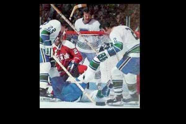 Doug Mohns with Canucks to the right, left, behind & below