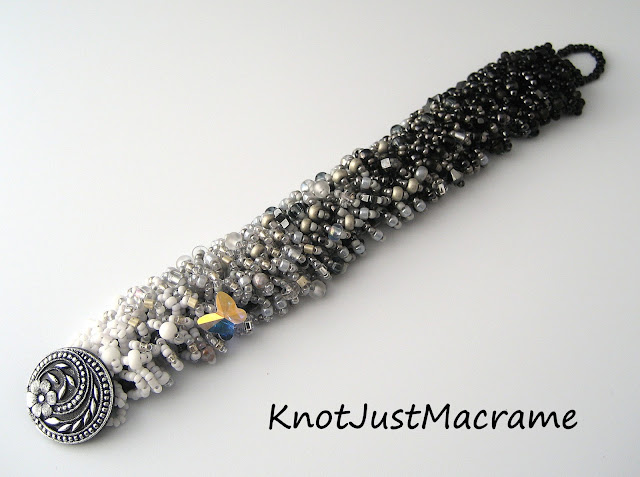 Completed caterpillar fringe bead weaving bracelet in black, gray (grey) and white.