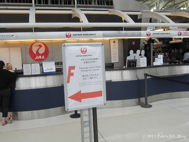 Sign telling JAL passengers with e-ticket to proceed to counters located in Aisle F at New York JFK
