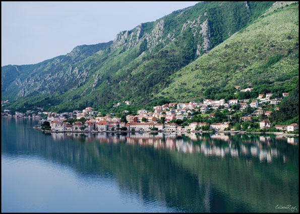 Shoreline views from the Bay of Kotor reflected in the water.
