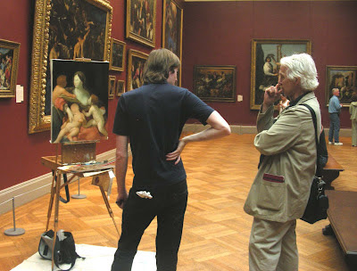 photo of two people standing together within a darkly painted art gallery