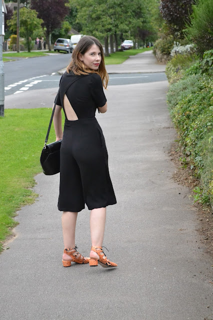Womens affordable highstreet fashion blog featuring British street style. Topshop Black button down playsuit with cut out back. orange snake skin lace mid heel shoes from ASOS. Black suede and leather and Topshop