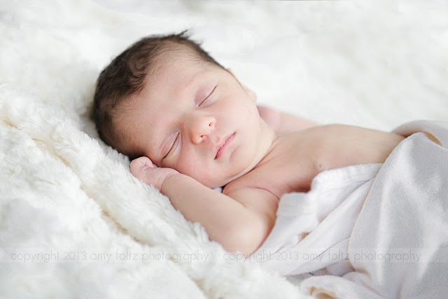 photo of a newborn boy asleep on a blanket