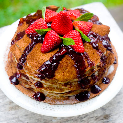 vegan gluten-free crepe cake with strawberries on top and coca powder