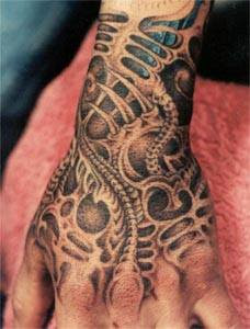 biomechanical tattoo depicting alien-like bones and tissues covering the wrist and the hand