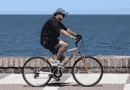 Sette benefici per la salute dell'esercizio fisico Uomo in bicicletta pedala sul lungomare