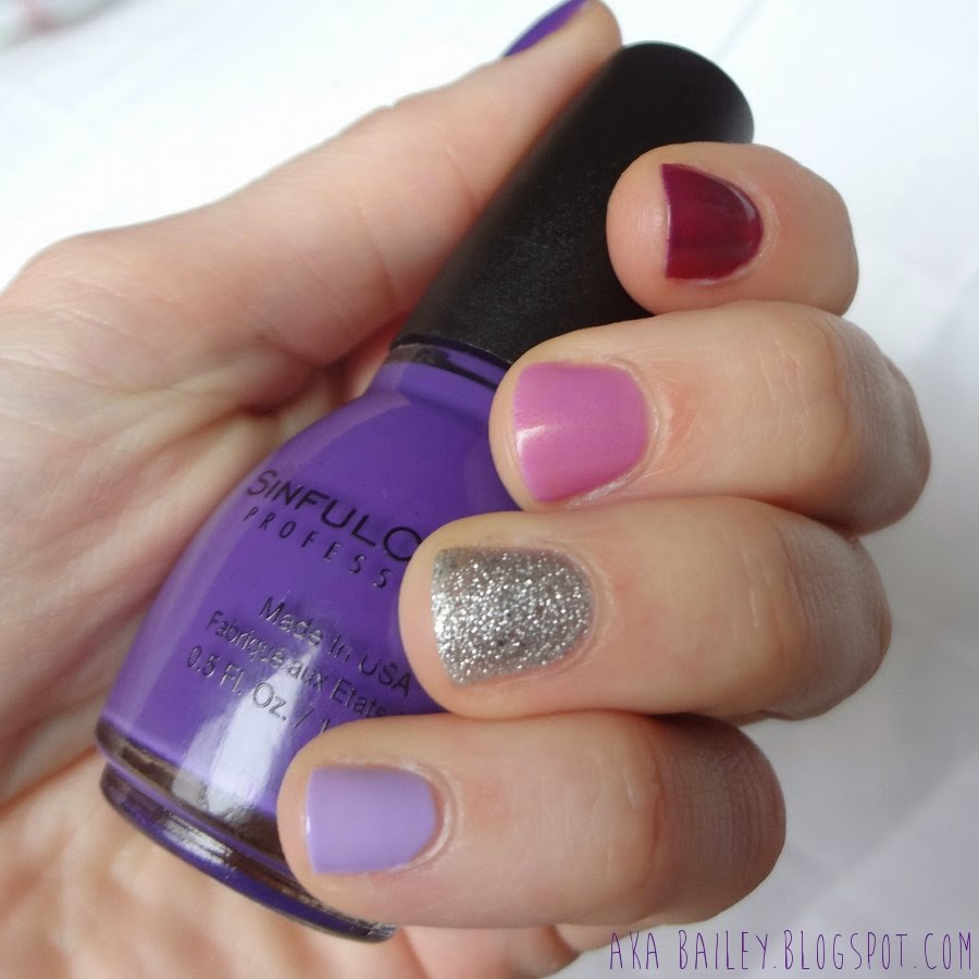 Different purples hues of nail polish, silver glitter accent nail