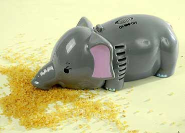 A gray plastic elephant with pink ears, which is also a hand vacuum, cleaning up crumbs