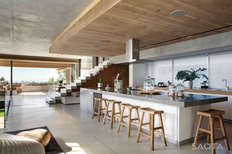 Photo of huge kitchen island with five wooden bar chairs