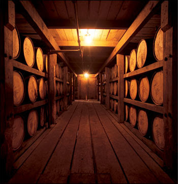 a view of many barrels of bourbon lined up on racks in the distillery