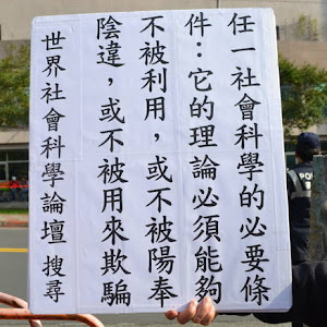 陳立民 Chen Lih Ming (陳哲) 創作出一個「社會科學成立的必要條件」命題。下方照片中見陳立民手執看板，照片拍攝於 20111203。