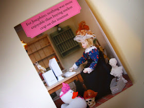 Greeting card showing a dolls house doll at a miniature computer, surrounded by random items. Card reads 'For Josephine, nothing was more enjoyable that buying useless crap on the internet'.