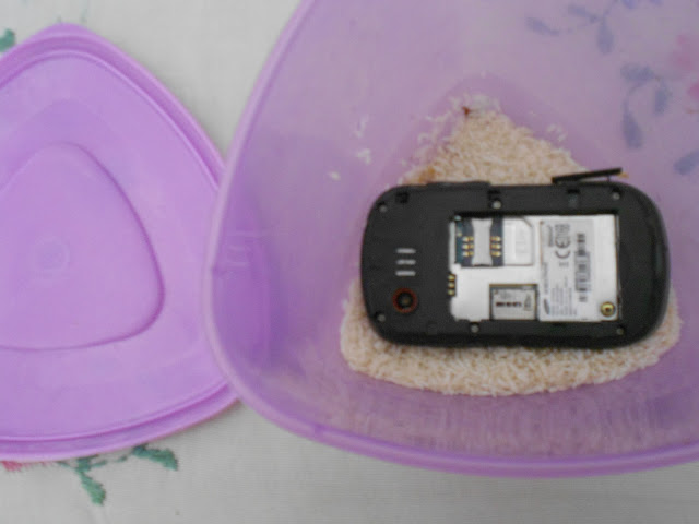 Mobile phone in a container with dry rice Mobile phone in a container with dry rice