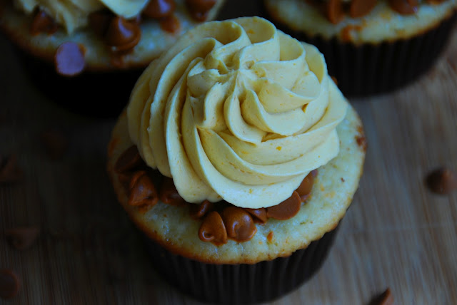 overhead close up of cupcake in brown wrapper with swirl of white icing on top