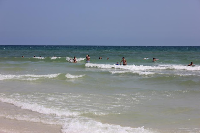 Ankle to shin high waves on Pensacola Beach at 18th. Ave with clear blue skies and tourists in the water