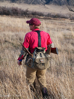 Happiness is a double on roosters! Hunter with pheasant tail feathers sticking out of a game bag