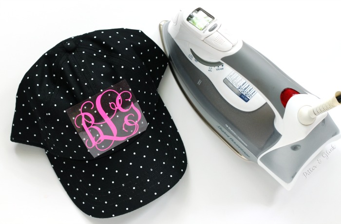 Ironing an HTV monogram cut with the Silhouette onto a hat. www.pitterandglink.com