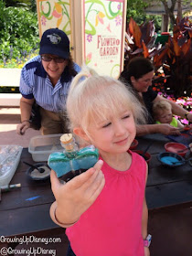 child showing sand art bottle at Epcot Flower and Garden Festival