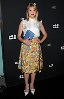 Dianna Agron  on the black carpet in a colorful skirt