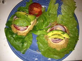 raw veggie burgers with cheese, avocado, tomatoes and red onion
