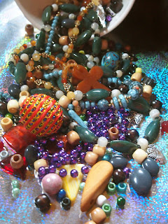 the bowl of beads has spilled all colors, sizes, shapes