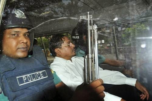 Muhammad Kamaruzzaman leaves a court escorted by policemen in Dhaka, Bangladesh, in May 2013.