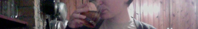 the lower half of a face sipping a dark drink on ice