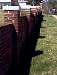 brick wall with a shadow on the ground