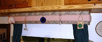 Pins hold small hanging items to the padded cornice.