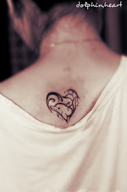 A dolphin tattoo design in the shape of a heart while combining with the waves.