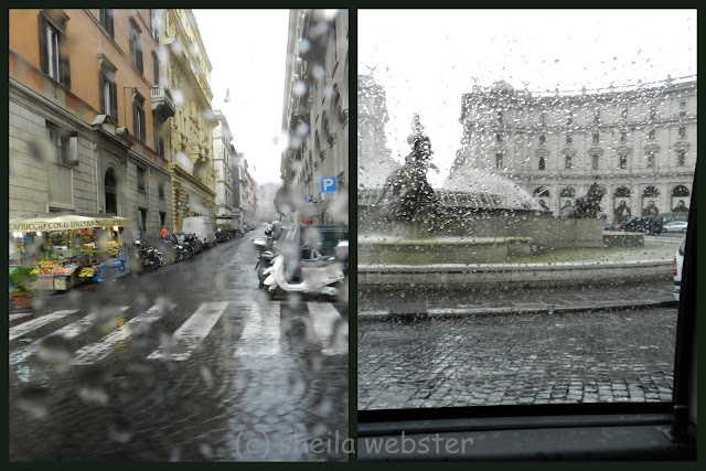 The rain spattered windows of the taxi cab blurred the view in Rome.