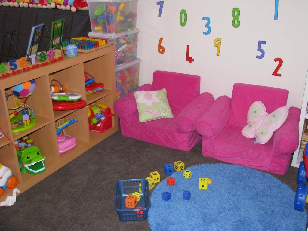cute round area rug also pink upholstered chairs and wooden toys shelving design plus numbers wall art for interior decorating idea