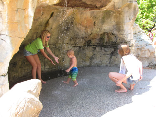 child playing in waterfall