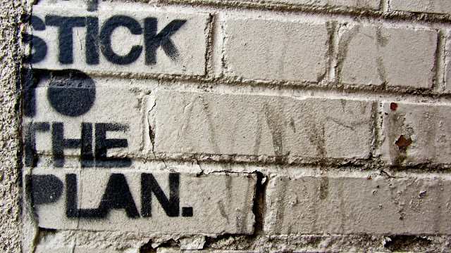 Denver graffiti quote that says 'STICK TO THE PLAN' on Tennyson.