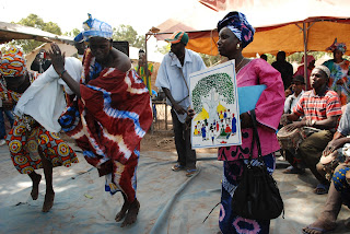 Women from Tankanto Maoundé dance with the image Tostan uses to represent the right to peace and security.