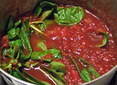 Red Tomatoes with Green Basil Cooking in Pot