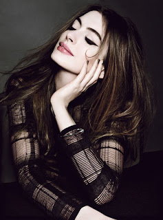 Anne Hathaway in a dark sweater thinking of something beautiful