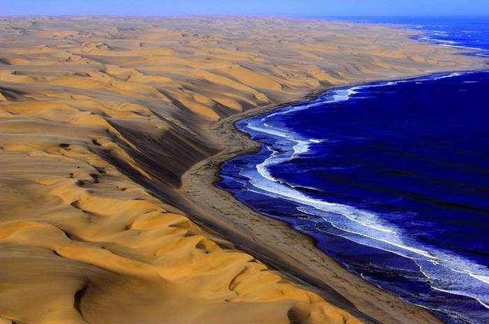 The Southern Namib desert is home to some of the tallest and most spectacular dunes of the world, ranging in color from pink to vivid orange. These dunes continue right to the edge of the Atlantic Ocean. The cold waters of the sea brushing against the dunes of the Namib desert is one of the most surreal sights.