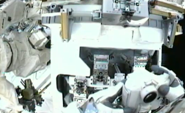 Atlantis – STS135 – Spacewalk on day 5. Astronaut Michael Fossum (20) holds a camera encased in thermal protection to take close up pictures of the materials experiment installed outside ISS. NASA-TV 2011.
