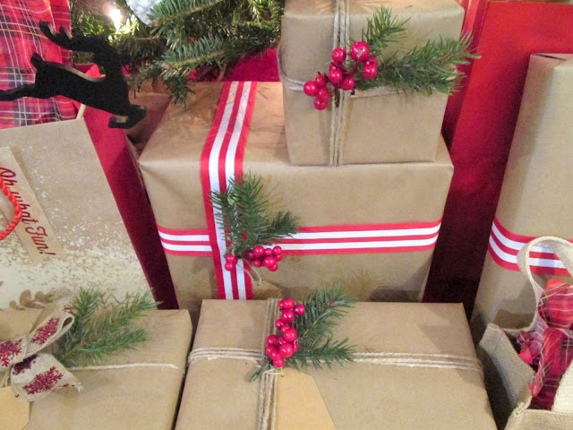 Wrapped Christmas gifts with tree sprigs, striped ribbon, berries, twine and brown paper. Rustic Chic