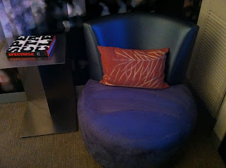 a blue chair with a red pillow