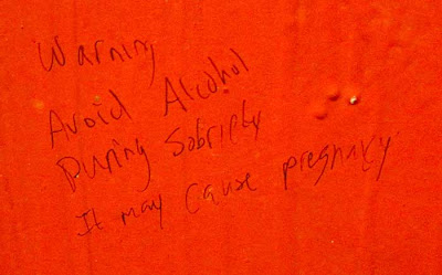 Graffiti on a red wall reading Alcohol consumed during sobriety causes pregnancy
