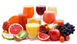 whole fruits and vegetables next to glasses of juice 