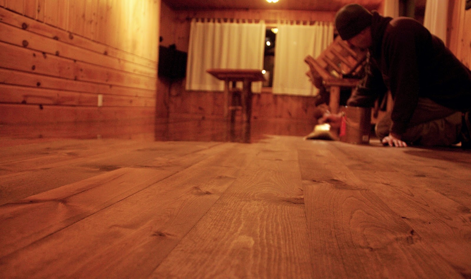 Finishing Chris Kuehn putting the first coat of finish onto the newly laid floor.