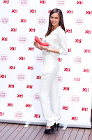 Irina Shayk in white outfit holding a red shoe