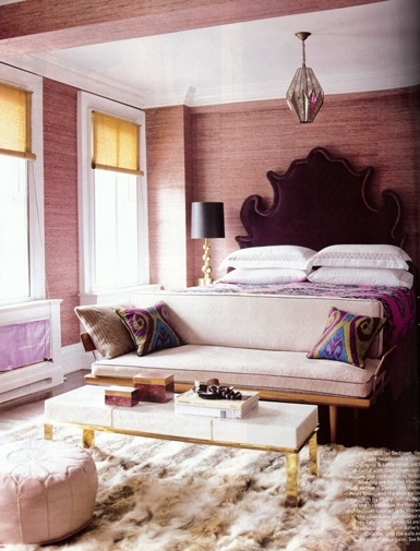 Bedroom seating area at foot of bed, couch and coffee table at foot of bed, bedroom, coffee table, couch at foot of bed, interiors, interior design, interiors inspiration, white settee, purple headboard, velvet headboard, moroccan headboard, shearling rug, fur rug, pink grasscloth, grasscloth walls, pink and purple bedroom, glamorous bedroom, glam bedroom, rich bedroom, moroccan poof
