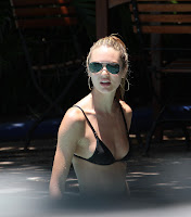Candice Swanepoel wearing a black bikini and sunglasses