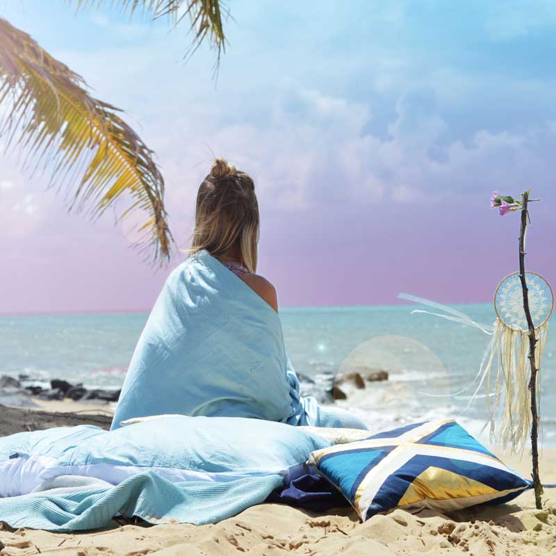 girl wrapped in blue sheets watching sunset over private tropical far north queensland beach girl wrapped in blue sheets watching sunset over private tropical far north queensland beach