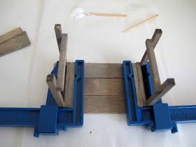 Dolls' house miniature potting table kit upside down, with legs glued on and clamped.