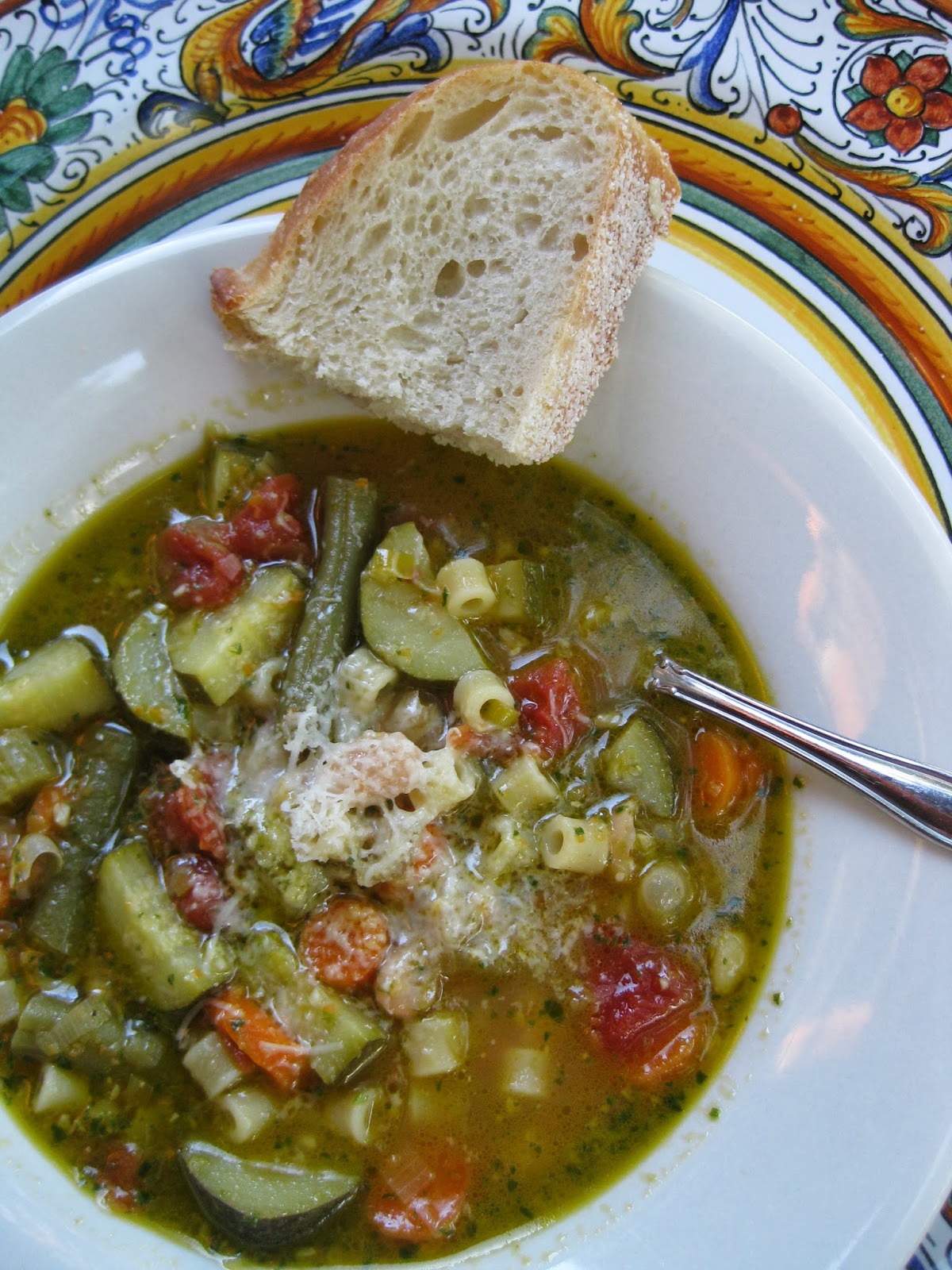 a bowl of vegetable soup with a slice of bread